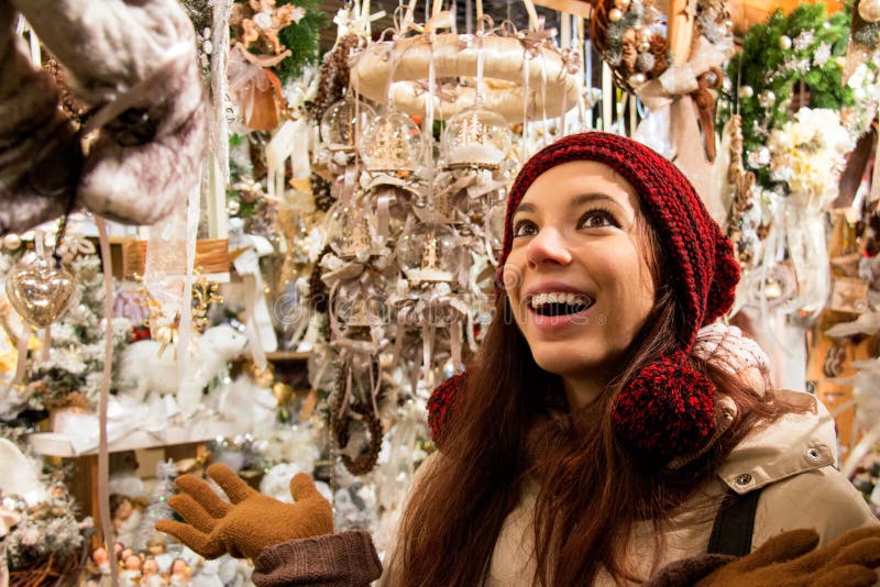 Femme heureuse de sourire devant des décorations d'arbre de Noël de lèche-vitrines d'affichage photographie stock libre de droits Femme heureuse de sourire devant des décorations d'arbre de Noël de lèche-vitrines d'affichage photographie stock libre de droits