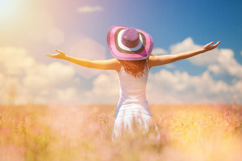 Femme heureuse enjoing la vie dans le domaine avec des fleurs photos stock Femme heureuse enjoing la vie dans le domaine avec des fleurs photos stock