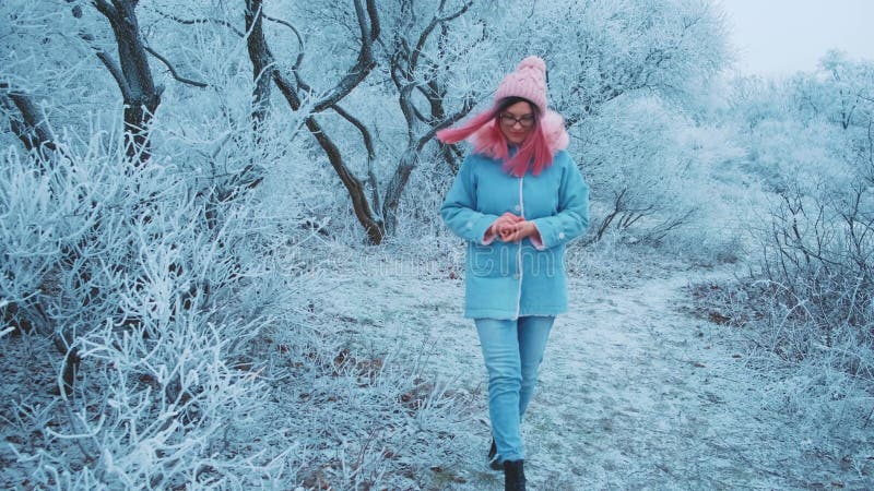 Femme heureuse marche. chapeau de veste bleue aux cheveux roses. toile de fond nature hivernale clips vidéos