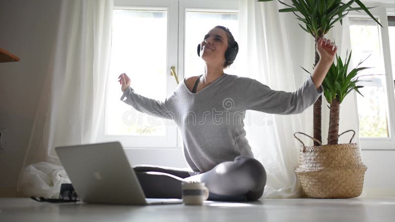 Femme heureuse profiter du temps de loisir à la maison avec ordinateur portable streaming musique. femme décontractée dansant et c