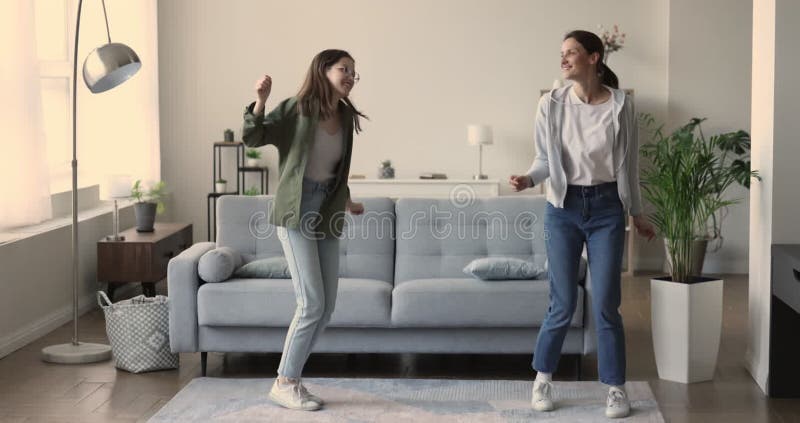 Femme heureuse sa fille adolescente chantant danser dans le salon clips vidéos