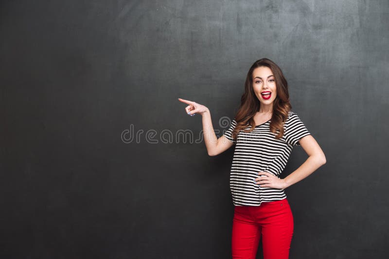 Femme heureuse se dirigeant loin et tenant le bras à la hanche image libre de droits Femme heureuse se dirigeant loin et tenant le bras à la hanche image libre de droits