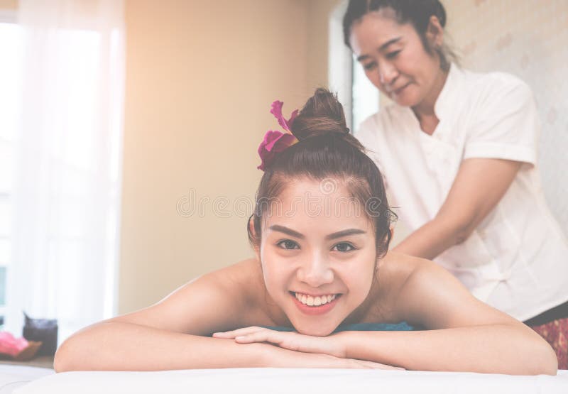 Femme heureuse se trouvant sur le lit de station thermale attendant pour faire le cours de station thermale photo stock Femme heureuse se trouvant sur le lit de station thermale attendant pour faire le cours de station thermale photo stock