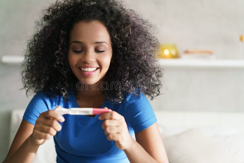 Femme heureuse souriant pour Joy With Pregnancy Test Kit image stock Femme heureuse souriant pour Joy With Pregnancy Test Kit image stock