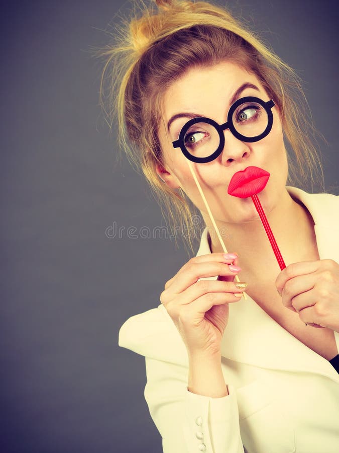 Femme heureuse tenant des accessoires de carnaval sur un bâton image stock