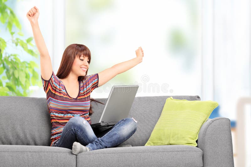 Femme heureuse travaillant sur l'ordinateur portable et faisant des gestes le bonheur