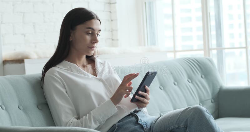 Femme heureuse utilisant smartphone profiter de chat avec un petit ami ou des collègues et lire de bons messages banque de vidéos