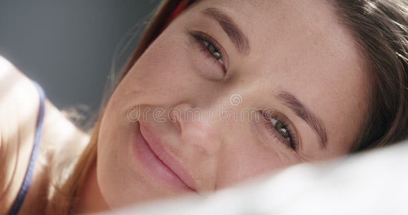 Femme heureuse visage et se détendre dans le lit à la maison sourire et se reposer dans la chambre le week-end. portrait de femme