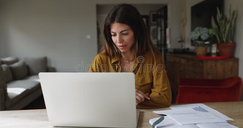Femme hispanique concentrée travaillant sur le projet freelance avec ordinateur portable banque de vidéos