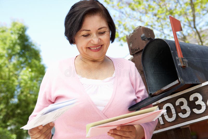 Femme hispanique supérieure vérifiant la boîte aux lettres images libres de droits Femme hispanique supérieure vérifiant la boîte aux lettres images libres de droits