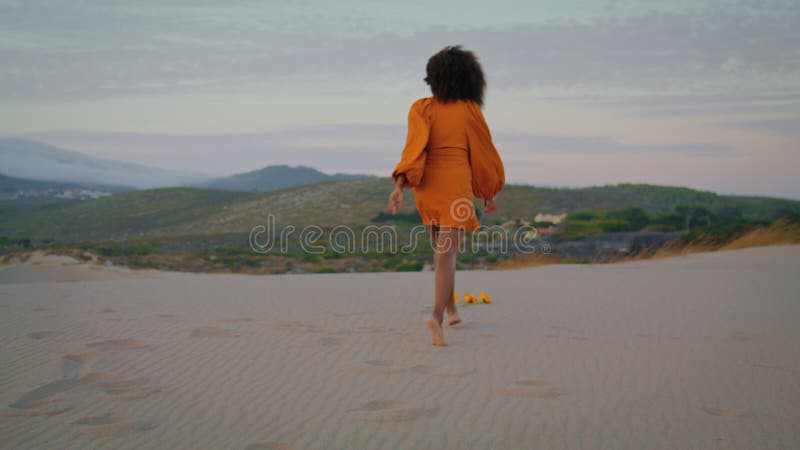 Femme jogging sable désert au crépuscule d'été. fille inconnue croupissant sur le sable. banque de vidéos