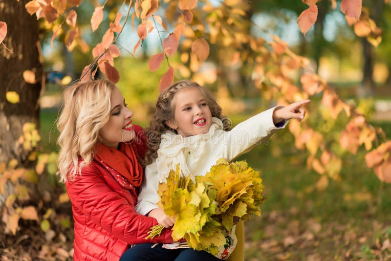 Femme joyeuse heureuse ayant l'amusement avec sa fille dans la couleur d'automne image libre de droits