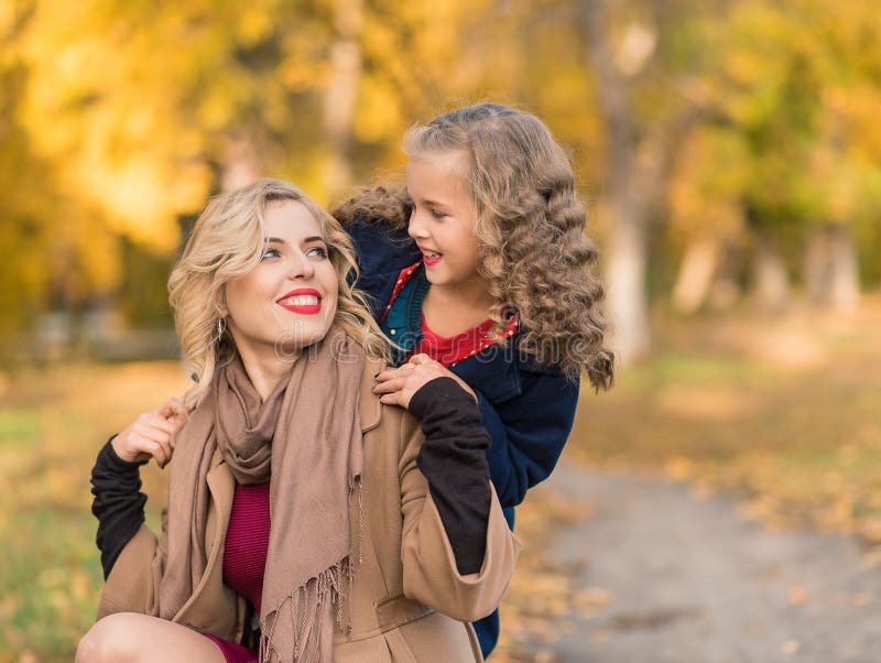 Femme joyeuse heureuse ayant l'amusement avec sa fille dans la couleur d'automne photo libre de droits