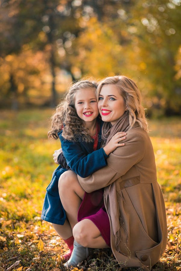 Femme joyeuse heureuse ayant l'amusement avec sa fille dans la couleur d'automne photographie stock libre de droits