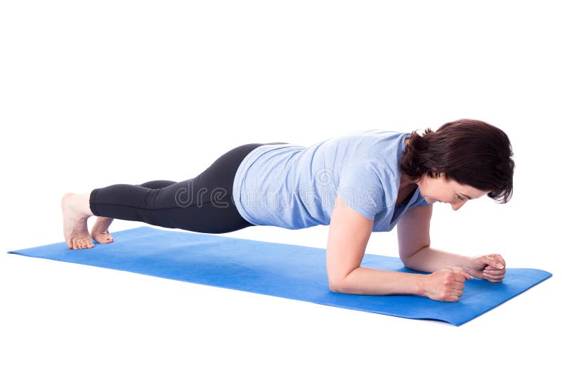 Femme mûre faisant des exercices sur le tapis de yoga d'isolement sur le blanc photographie stock libre de droits