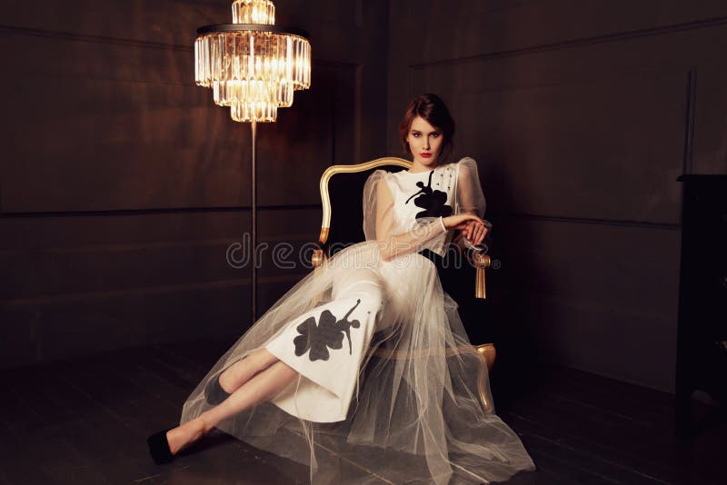 Femme magnifique avec le maquillage de cheveux foncés et de soirée dans la robe élégante posant dans le studio photographie stock Femme magnifique avec le maquillage de cheveux foncés et de soirée dans la robe élégante posant dans le studio photographie stock