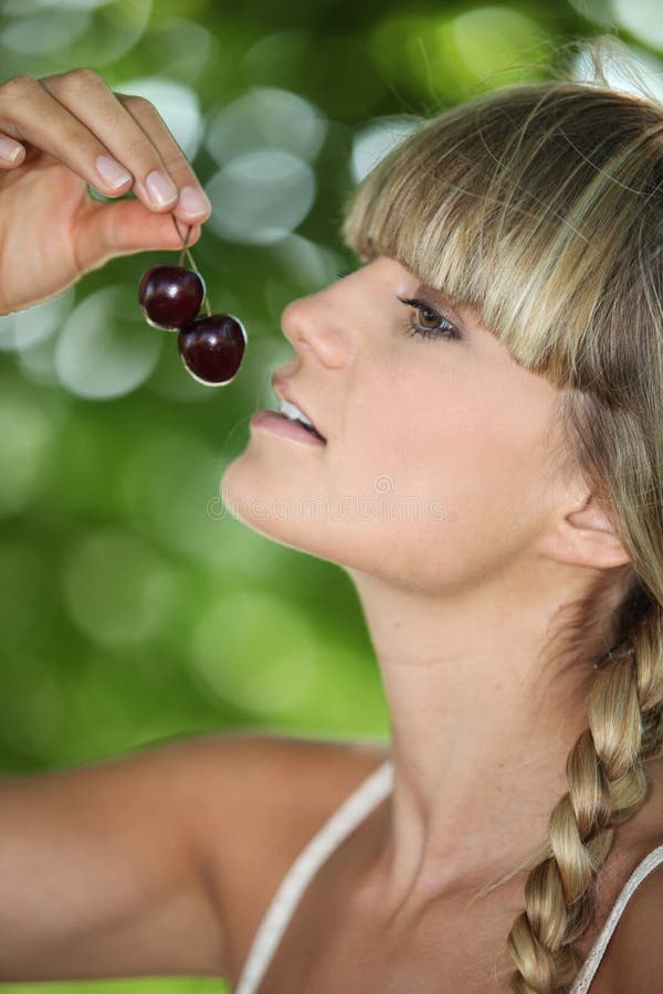 Femme mangeant des cerises photo stock Femme mangeant des cerises photo stock