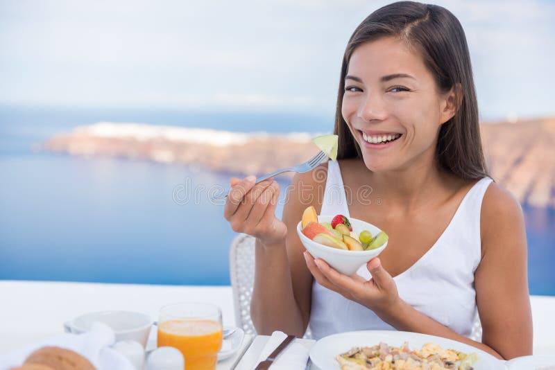 Femme mangeant le petit déjeuner sain de bol de salade de fruits photos stock Femme mangeant le petit déjeuner sain de bol de salade de fruits photos stock
