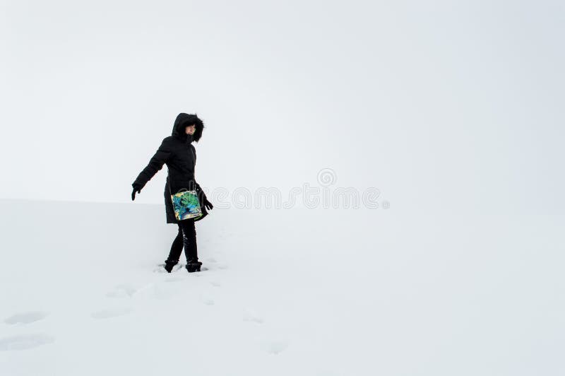 Femme marchant dans un domaine neigeux photos libres de droits Femme marchant dans un domaine neigeux photos libres de droits