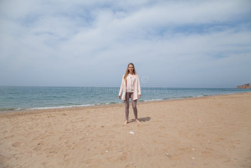 Femme marchant sur la plage sablonneuse, une côte photo stock Femme marchant sur la plage sablonneuse, une côte photo stock
