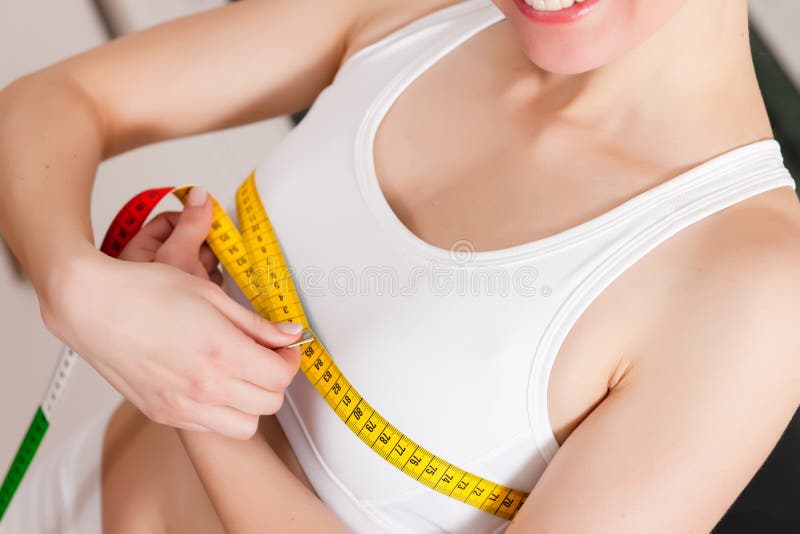 Femme mesurant son coffre avec la bande images stock Femme mesurant son coffre avec la bande images stock