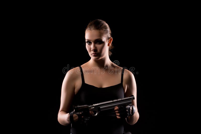 Femme militaire avec une arme à feu de sport au-dessus de fond noir images stock Femme militaire avec une arme à feu de sport au-dessus de fond noir images stock