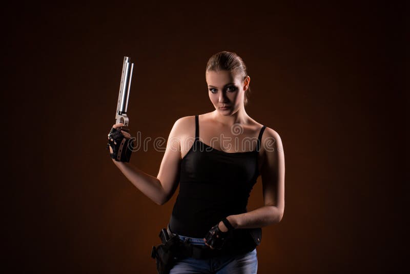 Femme militaire avec une arme à feu de sport au-dessus de fond noir photographie stock Femme militaire avec une arme à feu de sport au-dessus de fond noir photographie stock