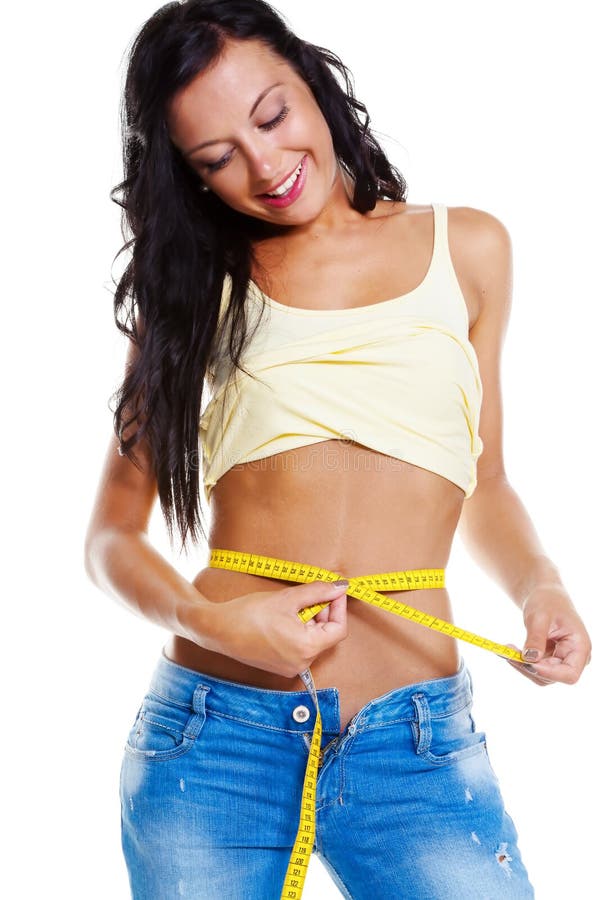 Femme mince dans des jeans avec la mesure de bande photos stock Femme mince dans des jeans avec la mesure de bande photos stock