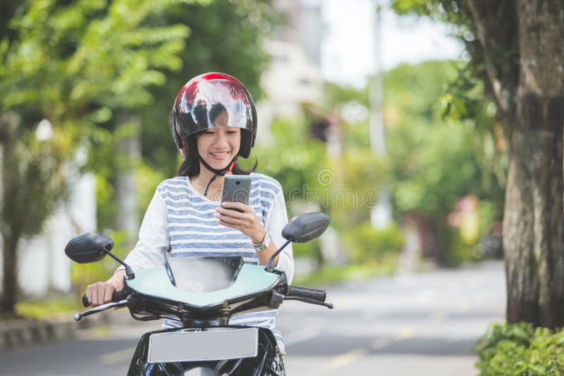 Femme montant un motorcyle ou une motocyclette photographie stock Femme montant un motorcyle ou une motocyclette photographie stock