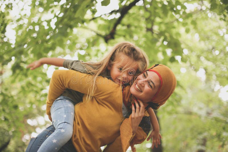 Femme musulmane avec l'enfant jouant dehors Sur le mouvement photos libres de droits