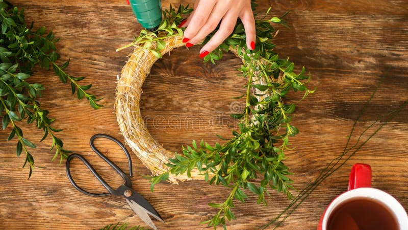 Femme méconnaissable faisant la guirlande de Noël dans le salon Concept de décoration de Noël de DIY Les mains se ferment vers le photographie stock Femme méconnaissable faisant la guirlande de Noël dans le salon Concept de décoration de Noël de DIY Les mains se ferment vers le photographie stock