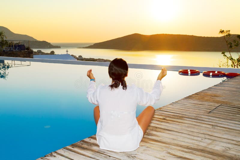 Femme méditant au lever de soleil photographie stock Femme méditant au lever de soleil photographie stock
