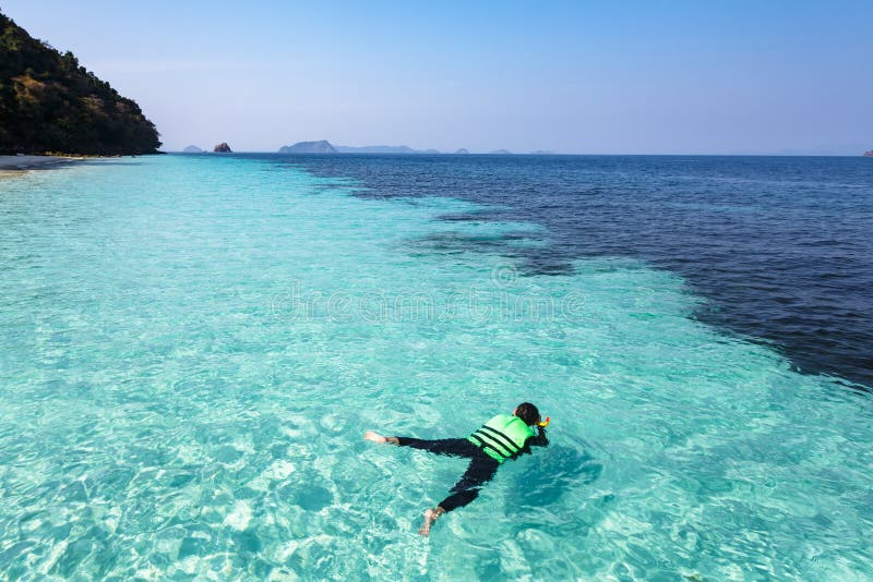 Femme naviguant au schnorchel dans l'eau clair comme de l'eau de roche, mer d'Andaman photographie stock libre de droits Femme naviguant au schnorchel dans l'eau clair comme de l'eau de roche, mer d'Andaman photographie stock libre de droits