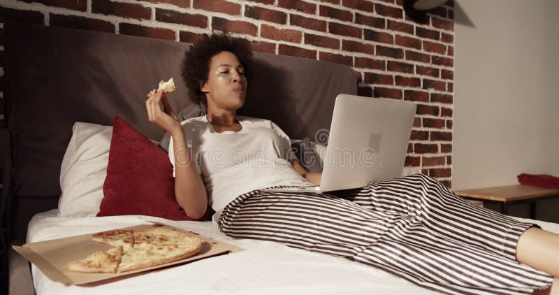 Femme noire en pyjama reposant sur le lit banque de vidéos