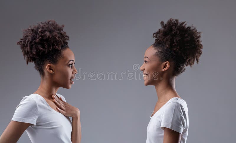 Femme noire murmure son reflet sourit sciemment images stock