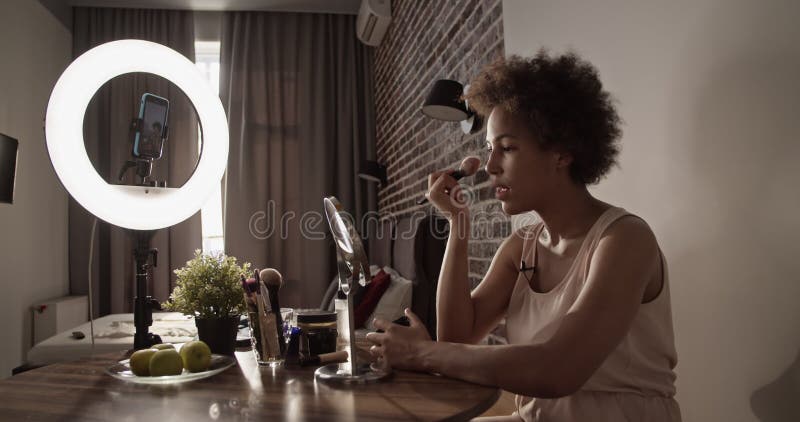 Femme noire utilisant du maquillage pendant la diffusion en direct banque de vidéos