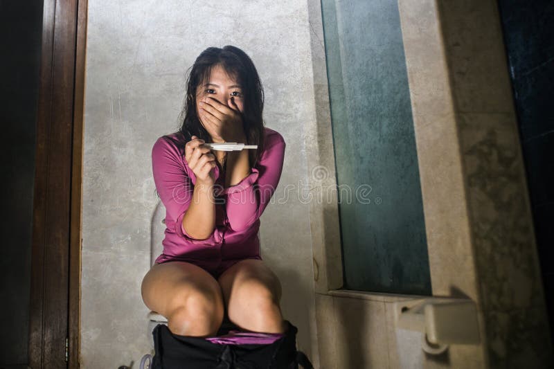 Femme ou adolescent japonaise asiatique enceinte désespérée vérifiant le résultat positif sur l'essai de facteur prédictif se rep image libre de droits Femme ou adolescent japonaise asiatique enceinte désespérée vérifiant le résultat positif sur l'essai de facteur prédictif se rep image libre de droits