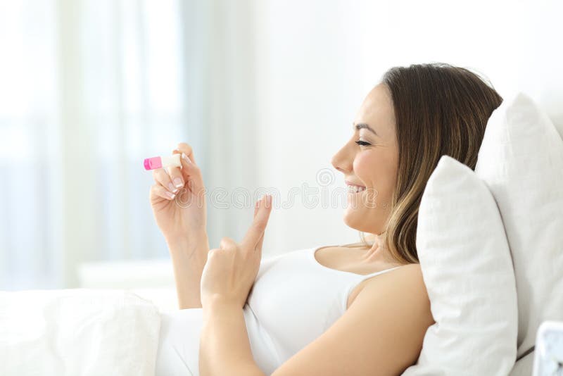 Femme pleine d'espoir vérifiant l'essai de grossesse à la maison photo stock Femme pleine d'espoir vérifiant l'essai de grossesse à la maison photo stock