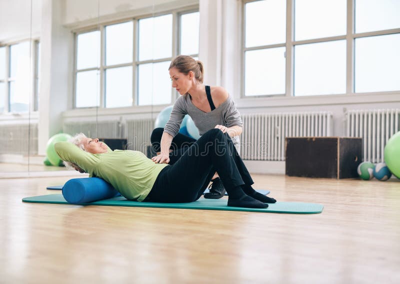 Femme plus âgée de aide de physiothérapeute au gymnase image stock Femme plus âgée de aide de physiothérapeute au gymnase image stock