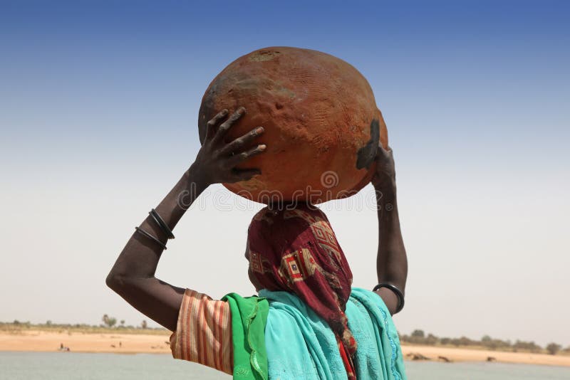 Young woman carrying a pot on her head. Young woman carrying a pot on her head