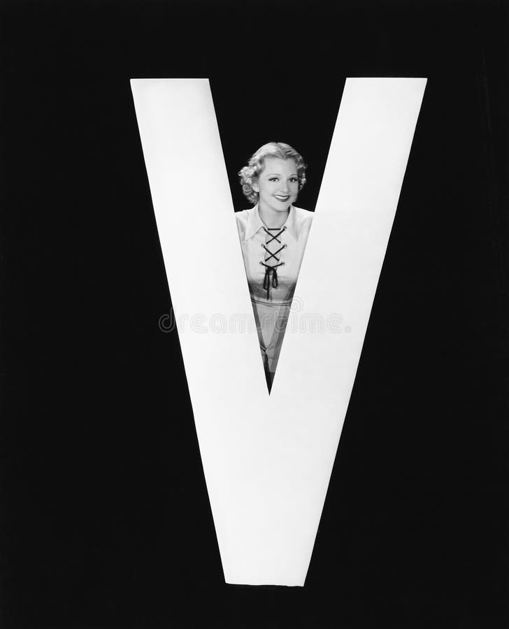 Femme posant avec la lettre énorme V (toutes les personnes représentées ne sont pas plus long vivantes et aucun domaine n'existe images stock Femme posant avec la lettre énorme V (toutes les personnes représentées ne sont pas plus long vivantes et aucun domaine n'existe images stock