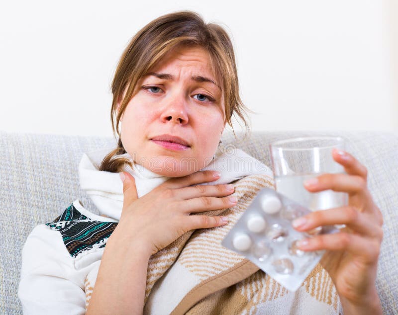 Femme prenant l'antibiotique contre la douleur de la gorge photo libre de droits