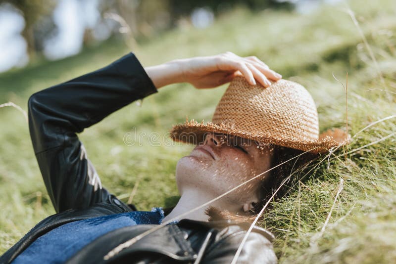 Femme prenant un petit somme sur l'herbe photographie stock Femme prenant un petit somme sur l'herbe photographie stock