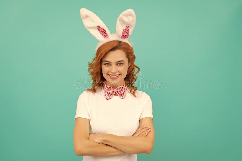 Femme pâques heureuse dans les oreilles de lapin et noeud d'arc sur fond bleu photos libres de droits