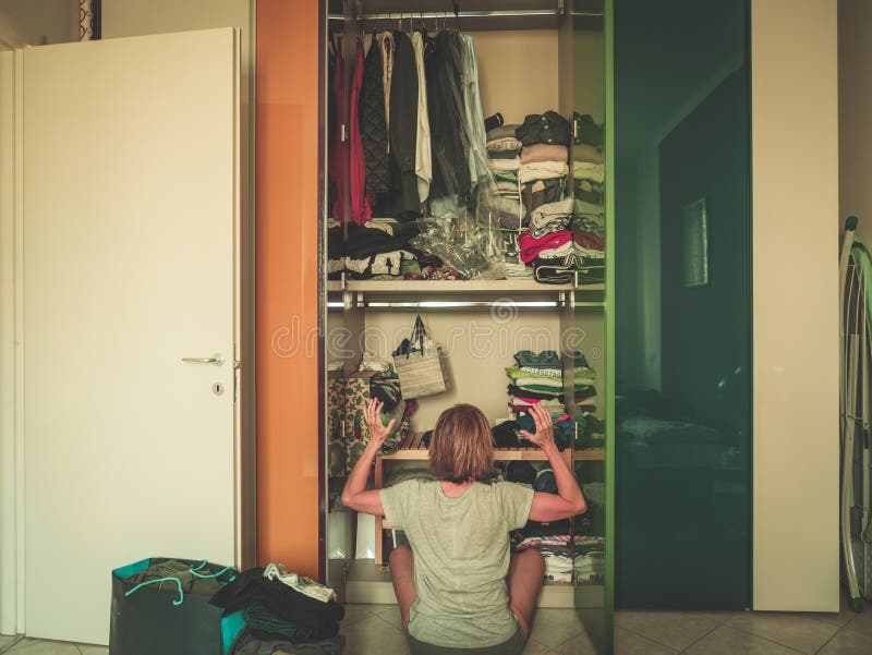 Femme regardant la garde-robe, intérieur de maison, femme au foyer désespérée, nettoyant à la maison, séance de vue arrière, styl photos libres de droits Femme regardant la garde-robe, intérieur de maison, femme au foyer désespérée, nettoyant à la maison, séance de vue arrière, styl photos libres de droits