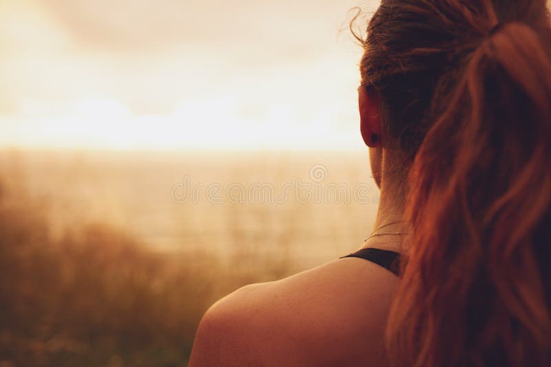 Femme regardant le coucher du soleil photographie stock Femme regardant le coucher du soleil photographie stock