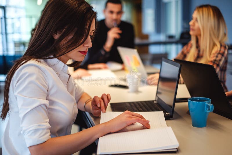 Femme regardant son programme dans le bureau photo libre de droits Femme regardant son programme dans le bureau photo libre de droits