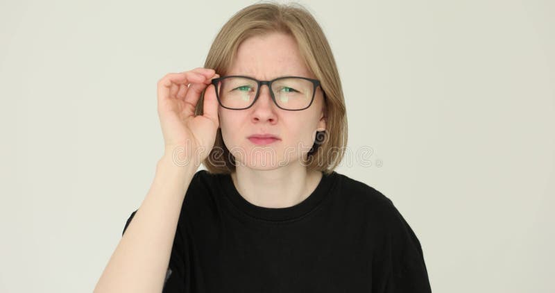 Femme regarde attentivement à travers les lunettes et regarde directement dans la caméra banque de vidéos
