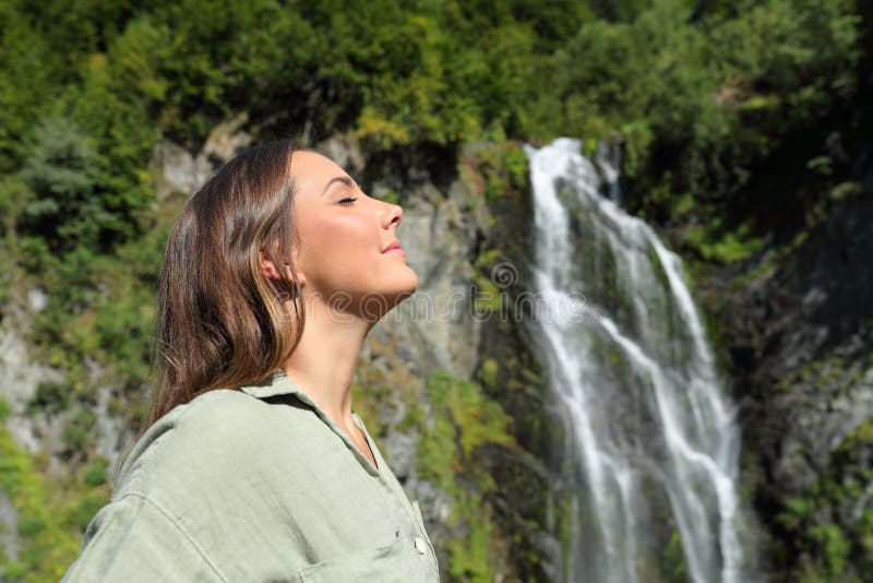 Femme respirant de l'air frais dans une cascade