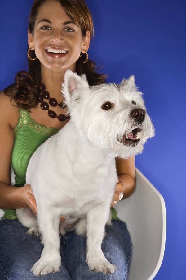 Femme retenant le chien terrier blanc. photo stock Femme retenant le chien terrier blanc. photo stock